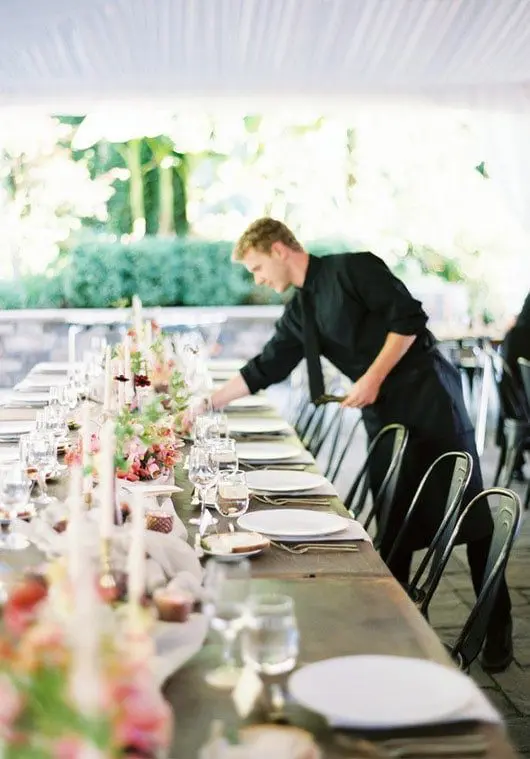 Man decorating a table | Lisa Dupar Catering | Wedding & Event Catering in Seattle