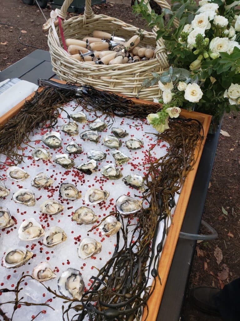 Oyster display on ice with florals at an outdoor Lisa Dupar Catering event