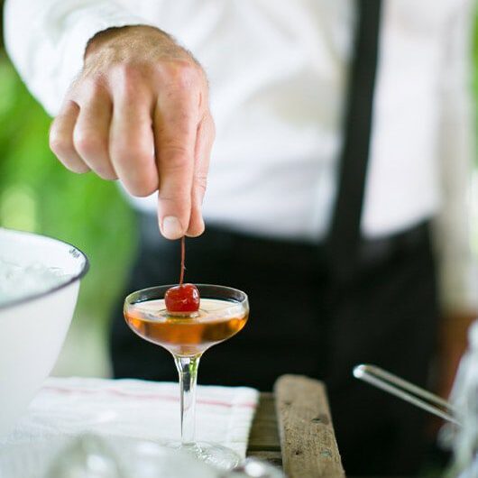 Waiter putting cherry on drink | Lisa Dupar Catering | Wedding & Event Catering in Seattle